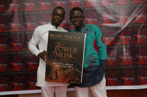 Trigga and his manager Jacob Danquah with the cover of the book.